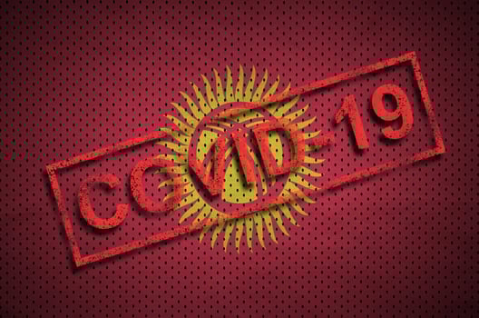 Kyrgyzstan flag and red Covid-19 stamp. Coronavirus 2019-nCov outbreak photo