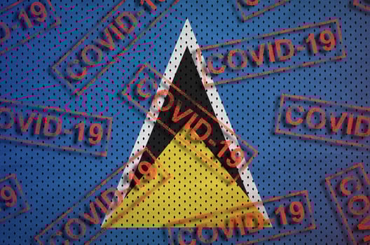 Saint Lucia flag and many red Covid-19 stamps. Coronavirus or 2019-nCov virus concept photo