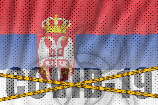 Serbia flag and Covid-19 inscription with orange quarantine border tape. Coronavirus or 2019-nCov virus concept photo
