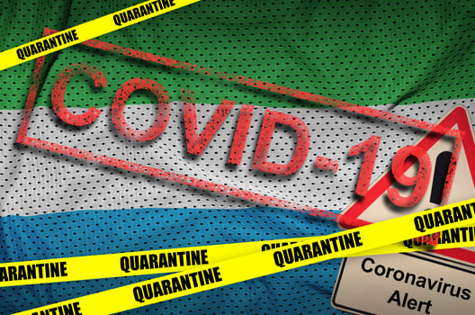 Sierra Leone flag and Covid-19 quarantine yellow tape with red stamp. Coronavirus or 2019-nCov virus photo