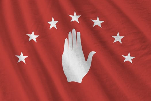 Abkhazia flag with big folds waving close up under the studio light indoors. The official symbols and colors in banner photo