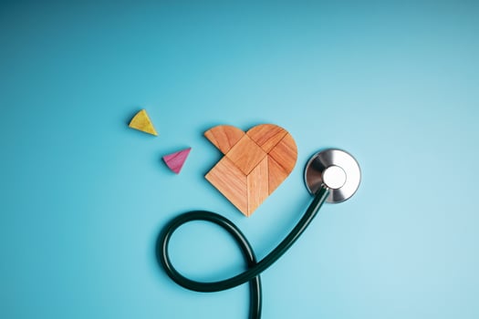 Health Care Concept. International World Heart Day. Wooden Jigsaw as Heart Shape with Stethoscope lay on Blue background. Life, Love and Care. Top View photo