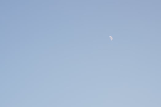 The moon rises during the day, the area is brightly colored. photo