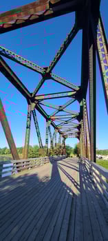 a old railway Trussell with a board walk and a blue sky photo