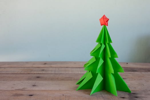 Concept origami the paper into christmas tree and red star on brown wooden table. photo