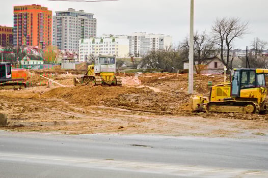 Many powerful industrial heavy specialized construction equipment of tractor excavators and bulldozers make road repairs during the construction of a new micro-district in a big city photo