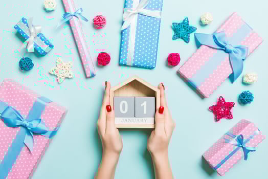 Top view of female hands holding calendar on blue background. The first of January. Holiday decorations. New Year concept photo