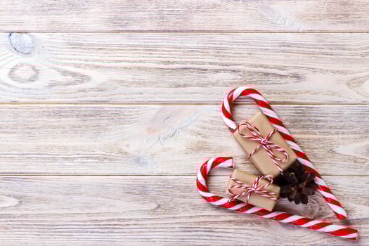 candy canes and christmas gift on brown wooden background photo