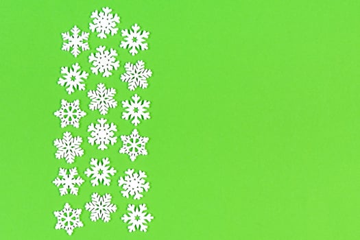 Top view of white snowflakes on colorful background. Winter weather concept with copy space. Merry Christmas concept photo