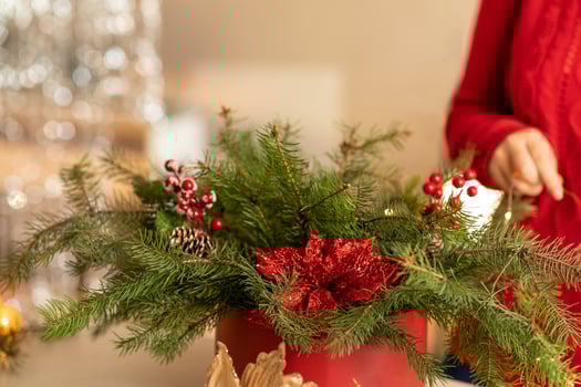 girl collects a Christmas bouquet of fir branches, flowers and Christmas tree decorations photo