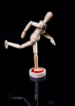 Image of wooden manikin on black background poses different posing photo