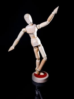 Image of wooden manikin on black background poses different posing photo