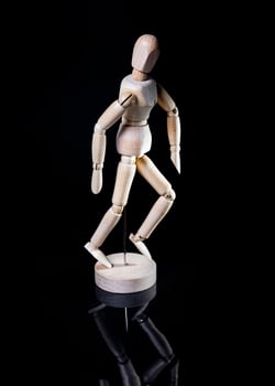 Image of wooden manikin on black background poses different posing photo