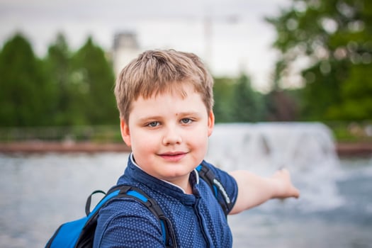 Portrait of a child, a boy against the backdrop of urban landscapes of skyscrapers and high-rise buildings in the open air. Children, Travel. Lifestyle in the city. Center, streets. photo