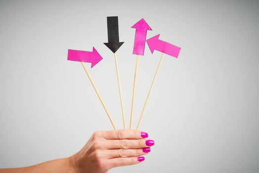 Female hand holding arrows over grey background photo
