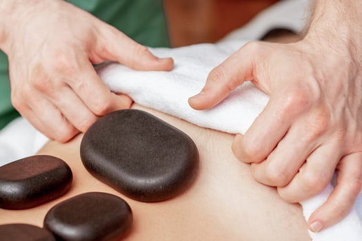Stone massage on back of man. photo