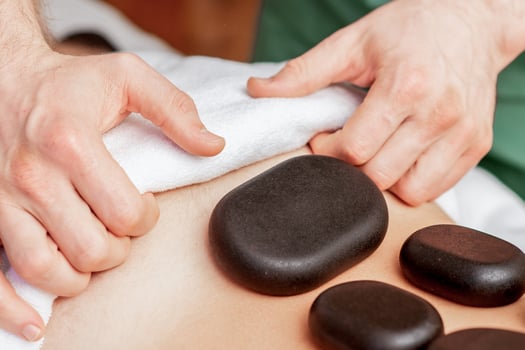 Stone massage on back of man. photo