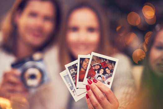 Beautiful couple celebrating Christmas at home and taking instant pictures photo