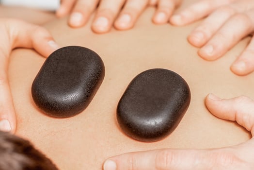 Stone massage on back of man. photo