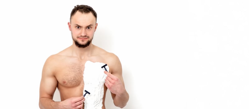 Young man shaving his chest photo
