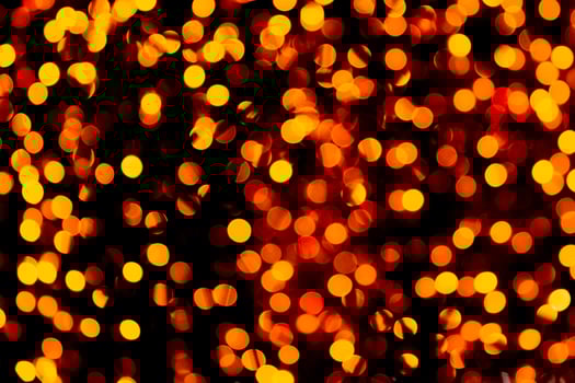 Unfocused abstract gold bokeh on black background. defocused and blurred many round light photo