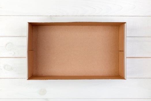 Empty Cardboard box on a white wooden background top view photo