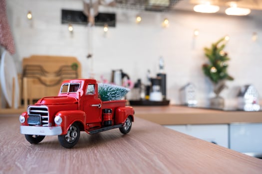 A red retro car with a Christmas tree decorates the festive kitchen for Christmas. Home decor, festive mood, New Year photo