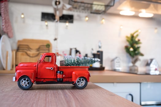 A red retro car with a Christmas tree decorates the festive kitchen for Christmas. Home decor, festive mood, New Year photo