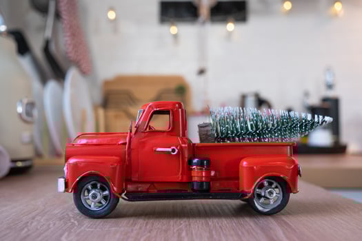 A red retro car with a Christmas tree decorates the festive kitchen for Christmas. Home decor, festive mood, New Year photo
