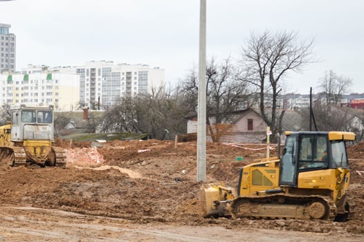 Many powerful industrial heavy specialized construction equipment of tractor excavators and bulldozers make road repairs during the construction of a new micro-district in a big city photo