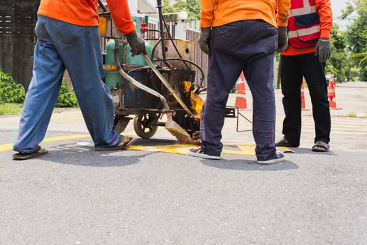 Group of road worker paint traffic lines on asphalt road surface. photo