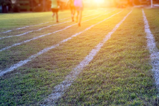 Outdoor white lines on grass field for practisting running at school in long distance area of Thaland. photo
