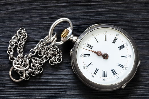 two minutes to twelve on old watch on black wood photo