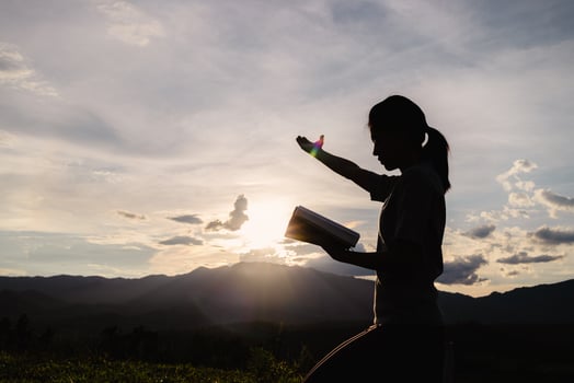 Silhouette of Religious young woman praying to God in the morning, spirtuality and religion,  Christians and Bible study concept. photo