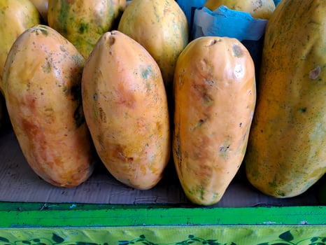 bunch of sweet orange papaya fruit. several big sweet papaya fruit put on wooden table on natural background for sale in fruit shop photo