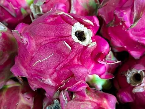 bunch of red sweet dragon fruit. several big sweet red dragon fruit put on wooden table on natural background for sale in fruit shop photo