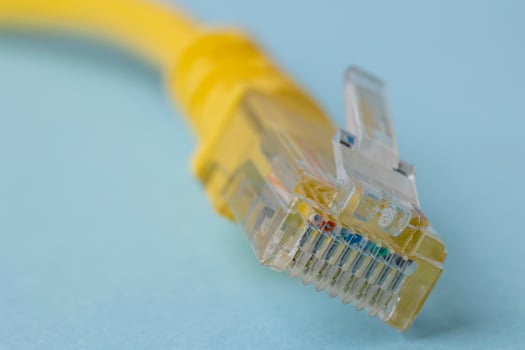 Closeup of yellow patch cord in blue background photo