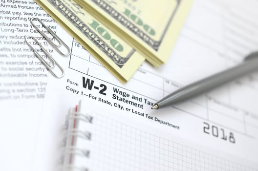 The pen, notebook and dollar bills is lies on the tax form W-2 Wage and Tax Statement. The time to pay taxes photo