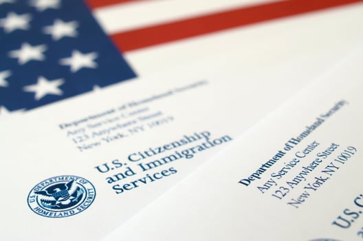 Envelopes with letter from USCIS on United States flag from Department of Homeland Security photo