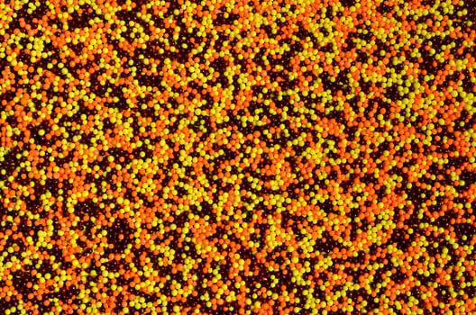 Background picture of a variety of colored glazed powder in the form of small balls photo