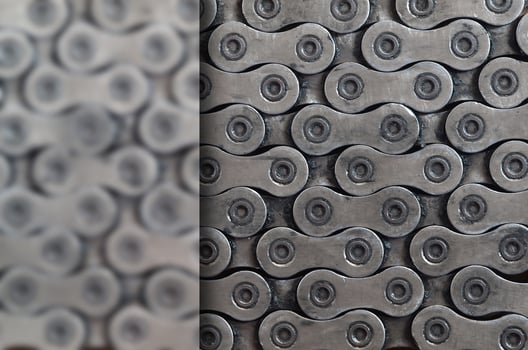 Dirty and oily chain from a mountain bike lying on a wooden table in a bicycle shop photo