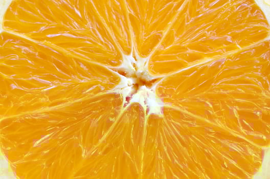 Top view of a fragment of the orange fruit slice close up. Macro background texture photo
