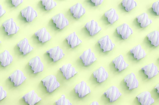 Colorful marshmallow laid out on lime paper background. pastel creative textured pattern photo
