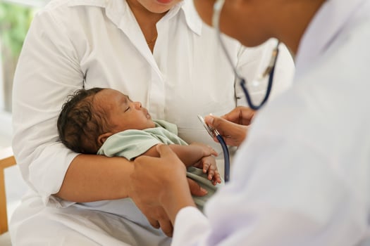 A newborn baby boy one-month-old mixed-race African-Thai, visiting the doctor for checkup health with stethoscope at the clinic pediatric. concept consultation, check-up, nurse, healing infant. photo