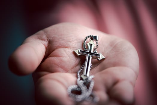 Spiritual christian hand holding Jesus cross necklace in the palm with faith and believe. photo