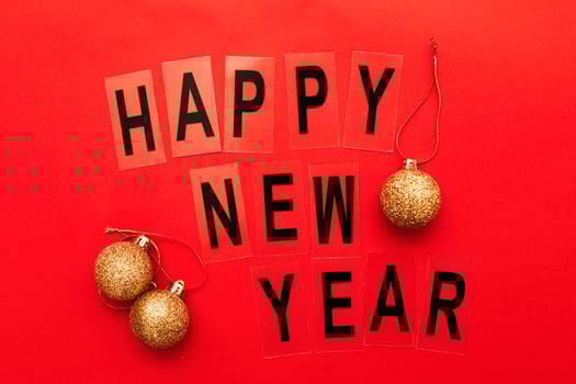 The inscription happy new year with shiny golden Christmas toy balls on a red background photo
