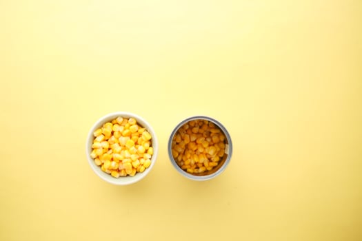 preserved corn in a tin container on yellow background photo
