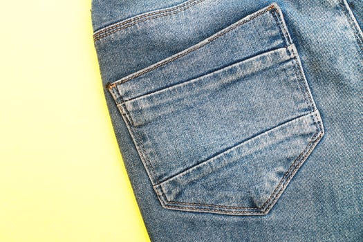 Back pockets of blue jeans on yellow background photo