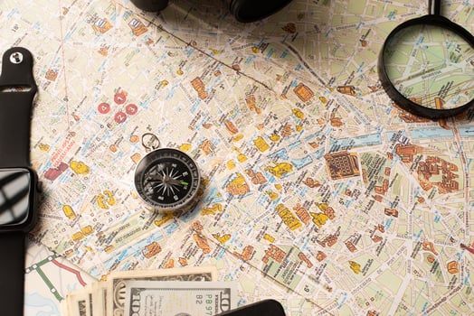 Flat lay traveler accessories on map, camera, glasses, digital devices photo