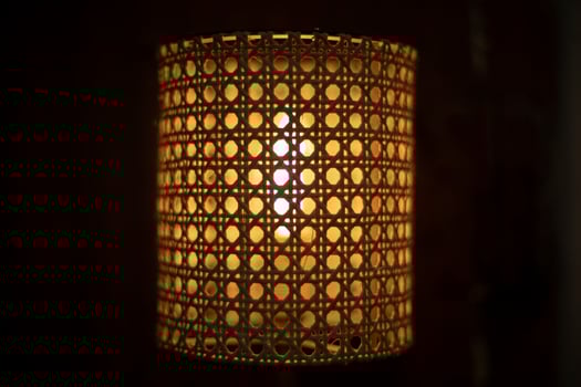 Lamp in dark. Wooden lampshade around incandescent lamp. photo
